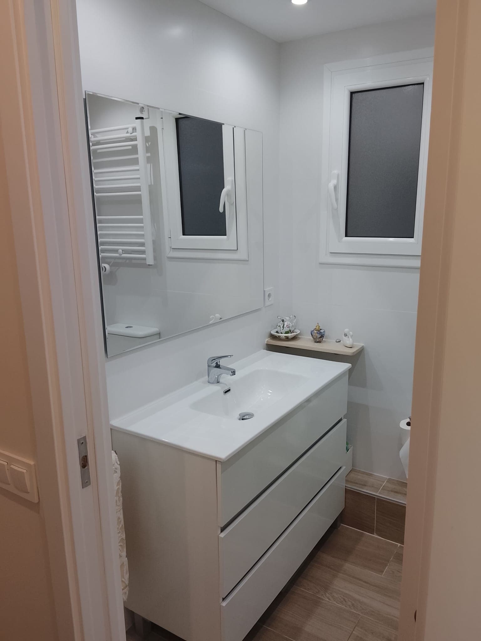 Baño reformado con lavabo, espejo y ventana