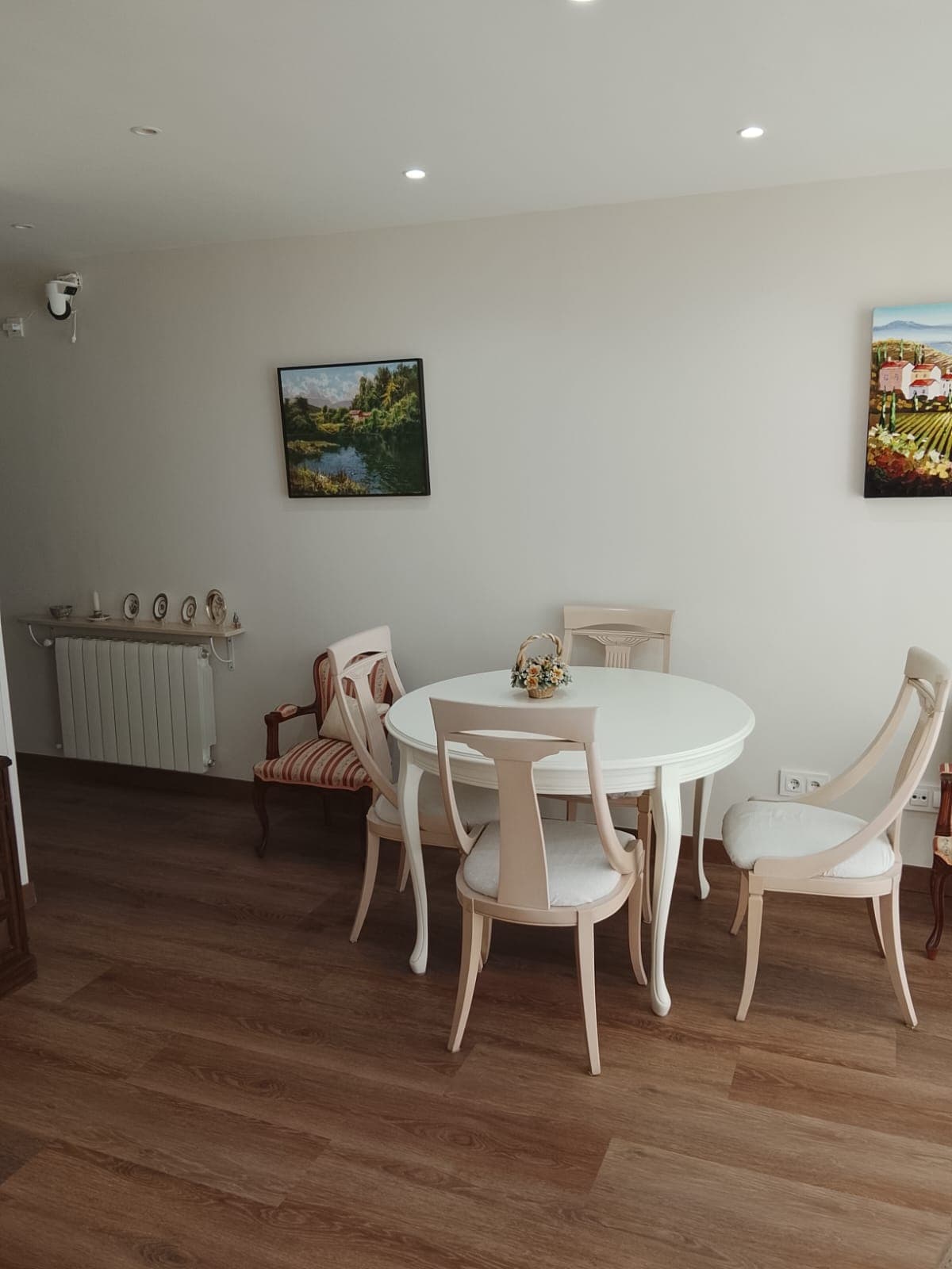 Comedor reformado con suelo laminado y mesa redonda