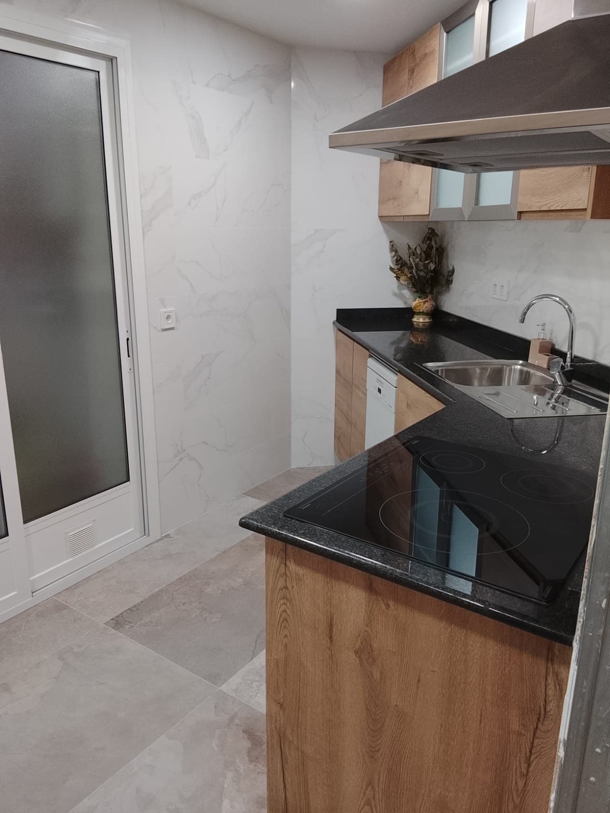 Detalle de cocina reformada con isla y vitrocerámica
