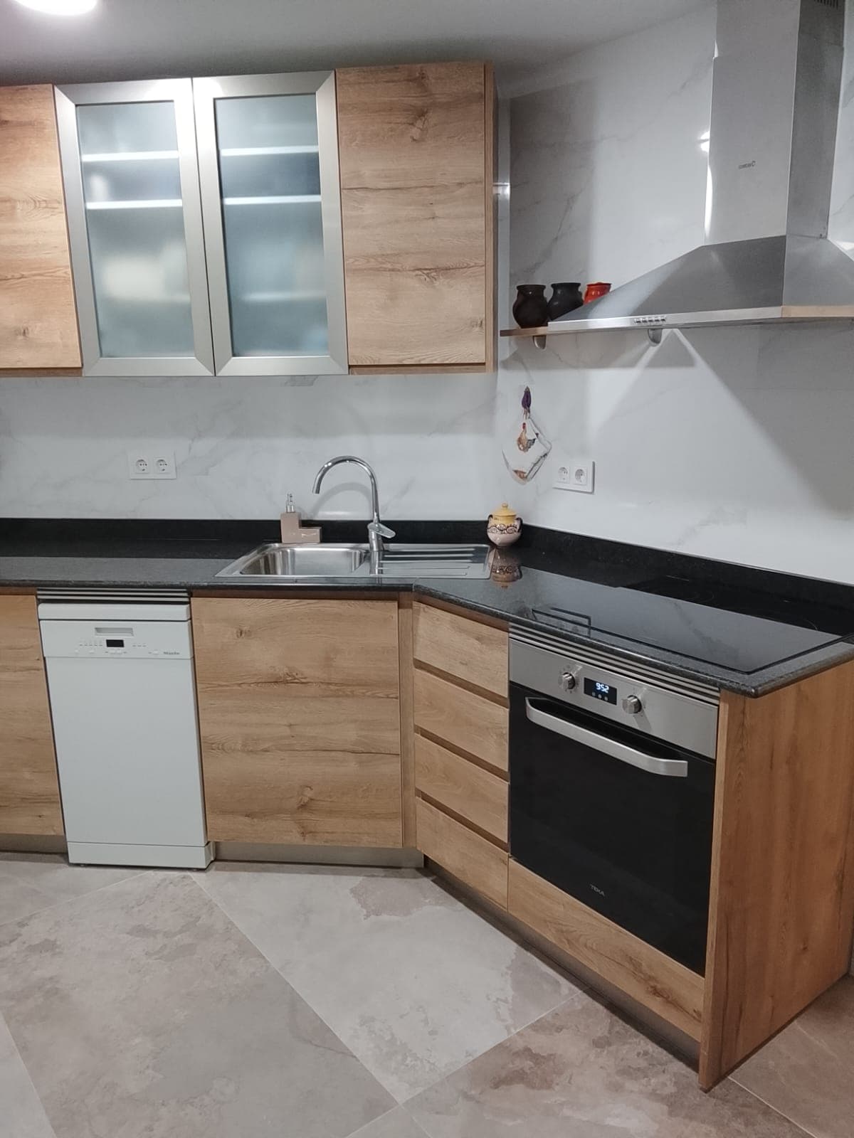 Cocina reformada con muebles de madera y electrodomésticos integrados