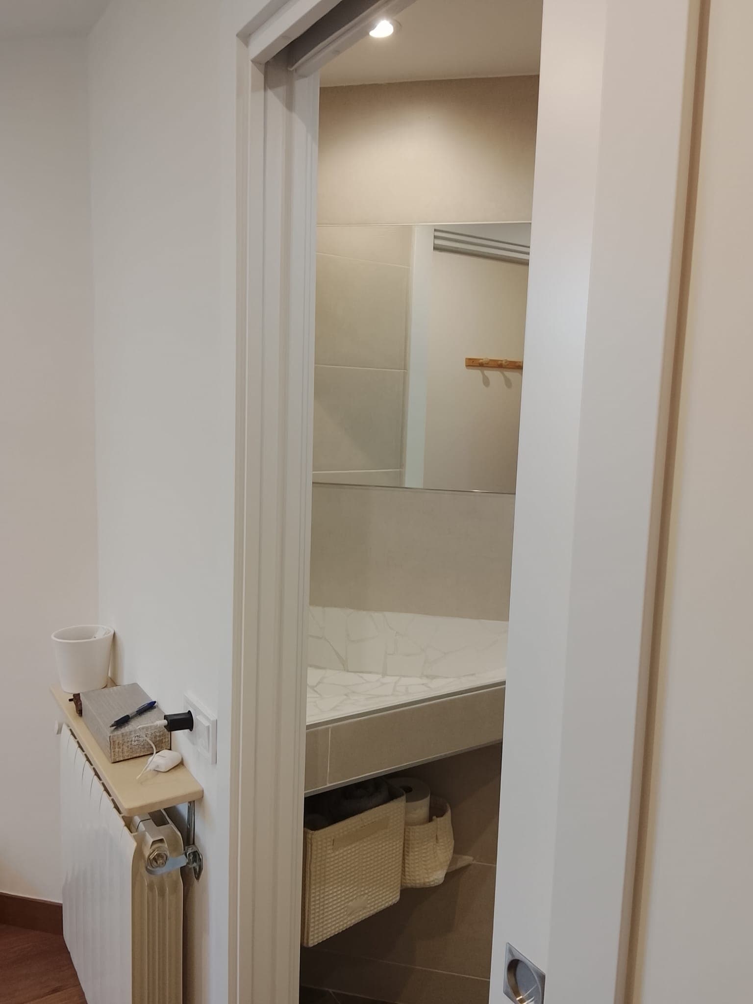 Baño reformado con toallero y mampara de ducha